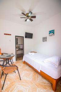 1 dormitorio con cama, mesa y ventilador de techo en HOSPEDAJE SANTA MONICA, en Tarapoto