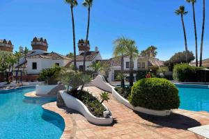 a resort with a swimming pool and palm trees at Villa Cana in San Roque
