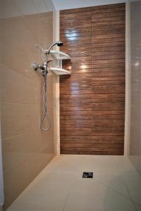a shower with a wooden door in a bathroom at Apartmány Anna in Liptovský Michal