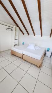 um quarto com uma cama e um piso branco em KAZ's à l'Anse Maurice em Gros Cap