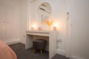 a dressing table with a mirror and a stool at Victoria Apartment 1 in Torquay