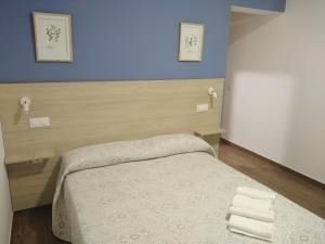 a bedroom with a bed and a blue wall at LA VILLA DE ORGAZ in Orgaz