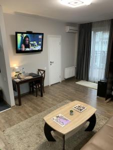 a living room with a table and a tv on the wall at Hotel Cisar in Lviv