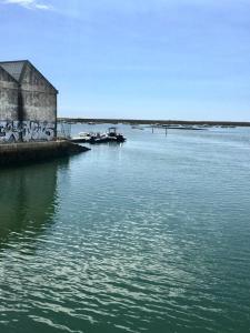 a large body of water with a building and a bridge at Casa dos Retratos Faro in Faro