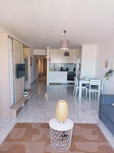 uma sala de estar e cozinha com um sofá e uma mesa em Cozy apartment PRAIA da ROCHA em Portimão