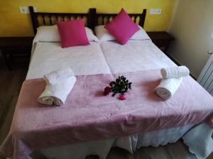 a bed with pink and white blankets and towels at Casa de David in Navas de San Antonio