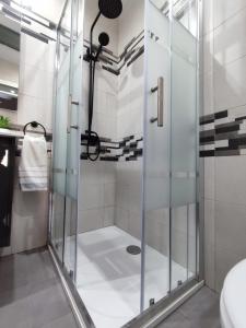 y baño con ducha y puerta de cristal. en Casa de David en Navas de San Antonio