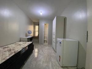 a bedroom with a bed and a refrigerator in it at Morar Bem in Sao Paulo