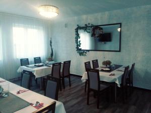 a dining room with tables and chairs and a mirror at Kresovia in Biłgoraj