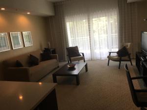 sala de estar con sofá, sillas y TV en 3/4 Villa at Provident Doral, en Miami