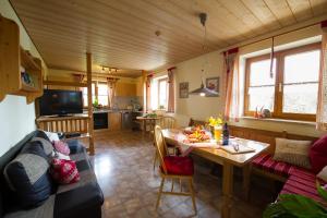 a living room with a couch and a table at Ferienwohnung Mohnblume in Burggen