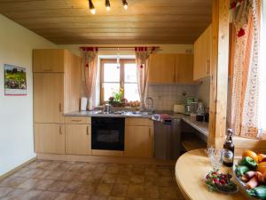 a kitchen with wooden cabinets and a table with fruits at Ferienwohnung Mohnblume in Burggen