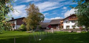 a house with a yard with a frisbee at Ferienwohnung Mohnblume in Burggen