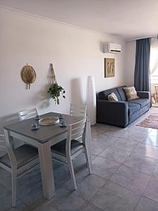 uma sala de estar com uma mesa e cadeiras e um sofá em Cozy apartment PRAIA da ROCHA em Portimão