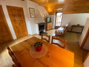 comedor y sala de estar con mesa de madera en Casa Rural Era de Ferro, en Erill la Vall