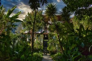 a resort with palm trees and a building in the background at Casa Lobo in San Pedro La Laguna
