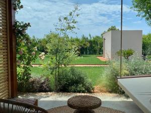 a view of a garden from a porch with a swing at Santa Lucia Maccarese - Residenza Agricola in Maccarese