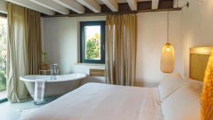 a bedroom with a bed and a tub and a window at Santa Lucia Maccarese - Residenza Agricola in Maccarese