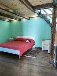 1 dormitorio con cama roja en el ático en Da Massimo-Casa Šimulni, en San Leonardo