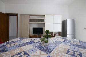 um quarto com uma cama grande com dois vasos de plantas em appartamento a 20 metri dalla spiaggia em Torre Lapillo