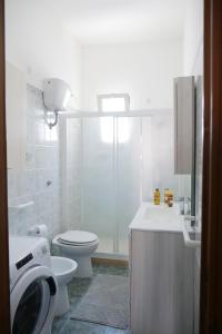 uma casa de banho com um WC, um lavatório e um chuveiro em appartamento a 20 metri dalla spiaggia em Torre Lapillo