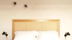 two lights above a bed with white pillows at Santa Lucia Maccarese - Residenza Agricola in Maccarese