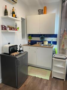 a small kitchen with white cabinets and a microwave at Heloise42 in Palermo