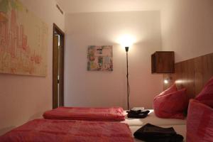 una camera da letto con un letto con lenzuola rosse e una lampada di Harz-Fewo KY487 a Braunlage Altre 17 foto