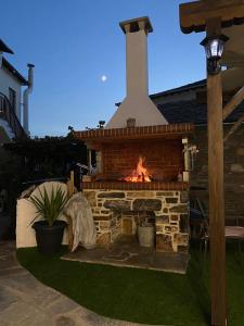 una chimenea de ladrillo en un patio con chimenea en VENUS GUESTHOUSE en Portariá