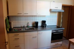 ヴェルニゲローデにあるFerienwohnung 8の白いキャビネットとシンク付きのキッチン