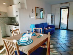 聖特雷莎加盧拉的住宿－La Filetta Alisei，厨房以及带桌子和蓝色沙发的用餐室。