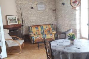 Gite de charme au cœur de la Brenne في Paulnay: غرفة معيشة مع طاولة وكرسي