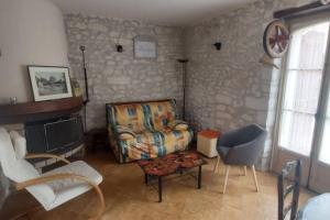 sala de estar con sofá y silla en Gite de charme au cœur de la Brenne, en Paulnay