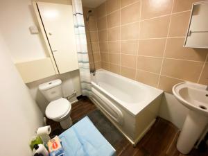 a bathroom with a toilet and a sink and a tub at Preston Stanley 1 Bed Flat 3a in Preston