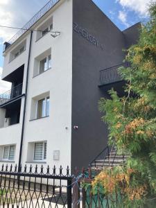 a white building with a sign on the side of it at Apartamenty W Domu in Białystok