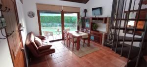 a living room with a table and chairs and a kitchen at Casa da Croa in Laxe