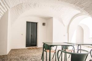 een kamer met 2 tafels en stoelen en een zwarte deur bij Casa do Sembrano in Beja