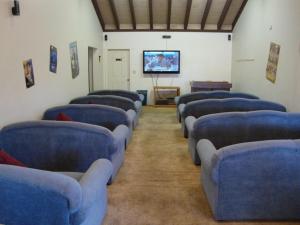 eine Reihe blauer Stühle in einem Zimmer mit einem Bildschirm in der Unterkunft Roundhouse Resort, a VRI resort in Pinetop-Lakeside