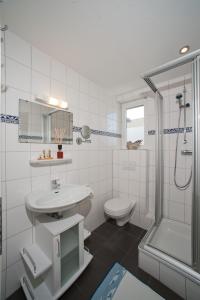 ein Bad mit einem Waschbecken, einem WC und einer Dusche in der Unterkunft Haus Gud Hööb Whg 02 in Wyk auf Föhr