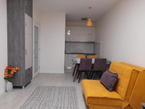 a living room with a yellow couch and a table at Apartment Diamond in Podgorica