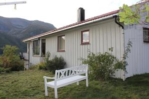 Tustna的住宿－Landlig hus på kysten，坐在房子前面的白色长凳