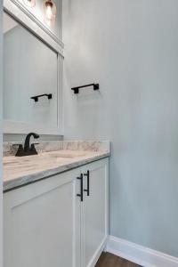a white bathroom with a sink and a mirror at Saltwater Gospel in Oak Island