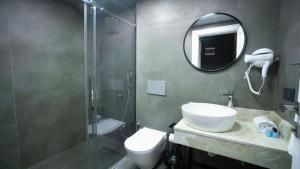 a bathroom with a shower and a toilet and a sink at Estera Hotel Silent in Antalya
