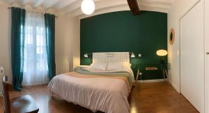 a bedroom with a bed with a green wall at Logroño Best Choice Apartament in Logroño