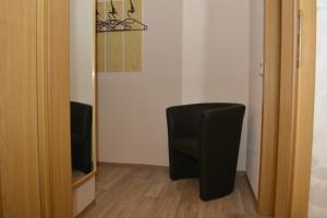 a black chair sitting in a room next to a mirror at Ferienwohnung Elisabeth in Egloffstein