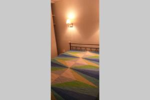 1 dormitorio con 1 cama con colcha colorida en superbe appartement T3 traversant avec place de parking, en Rodez