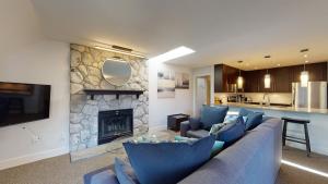 a living room with a couch and a fireplace at Modern Home with Forested Views by Harmony Whistler in Whistler