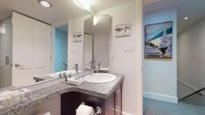a bathroom with a sink and a mirror at Modern Home with Forested Views by Harmony Whistler in Whistler +49 photos