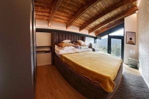 a bedroom with a large bed with a large window at Vila Pohoda in Donovaly