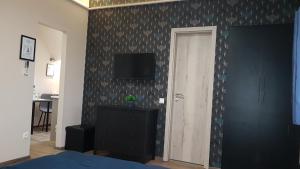 1 dormitorio con pared, TV y puerta en Sarokház Tihany en Tihany